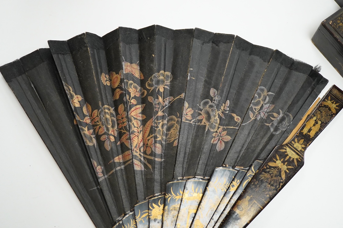 Four 19th century Chinese gilt-decorated black lacquer fans with figure painted leaves, two cased, largest 41cm